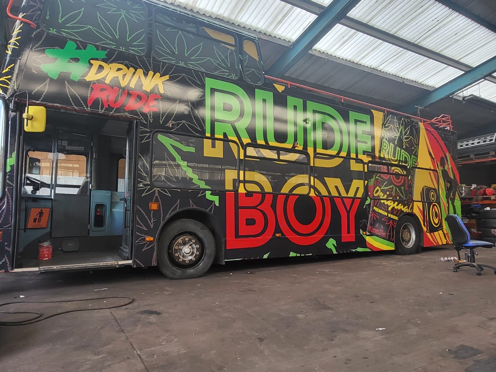 Side view of a vibrant Rude Boy bus wrap